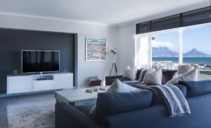 a home living room with a blue sofa and wall mounted tv controlled by home automation systems