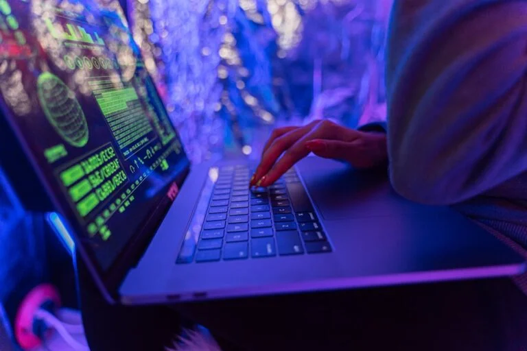 a computer tech on his laptop installing cybersecurity